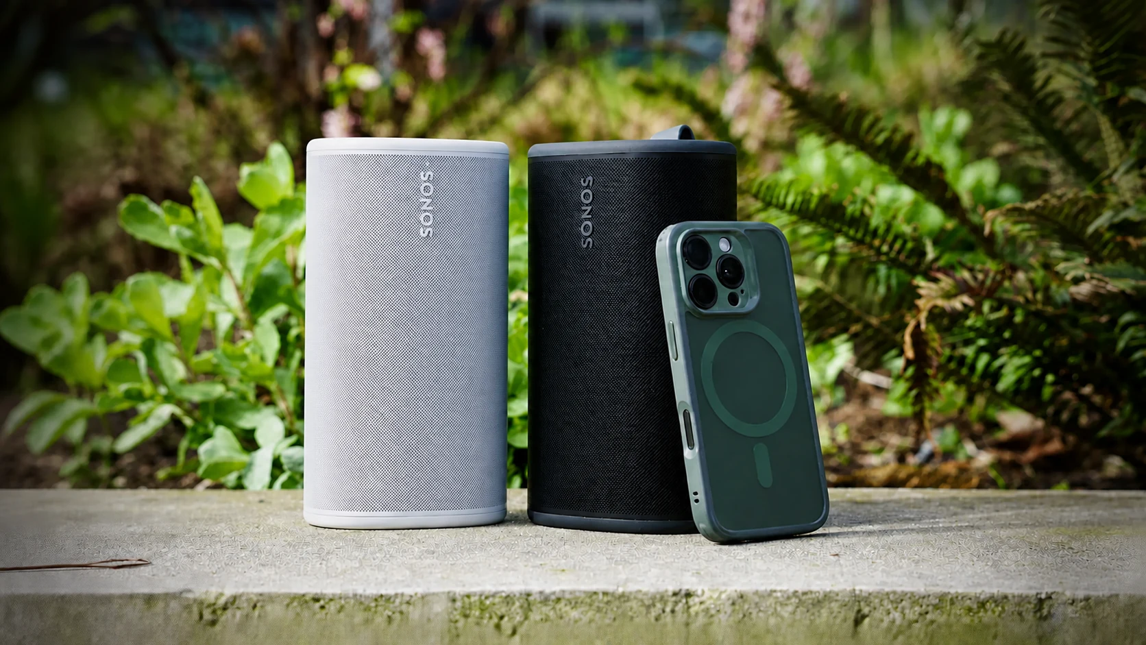 White and black Sonos speakers paired outdoors with a phone